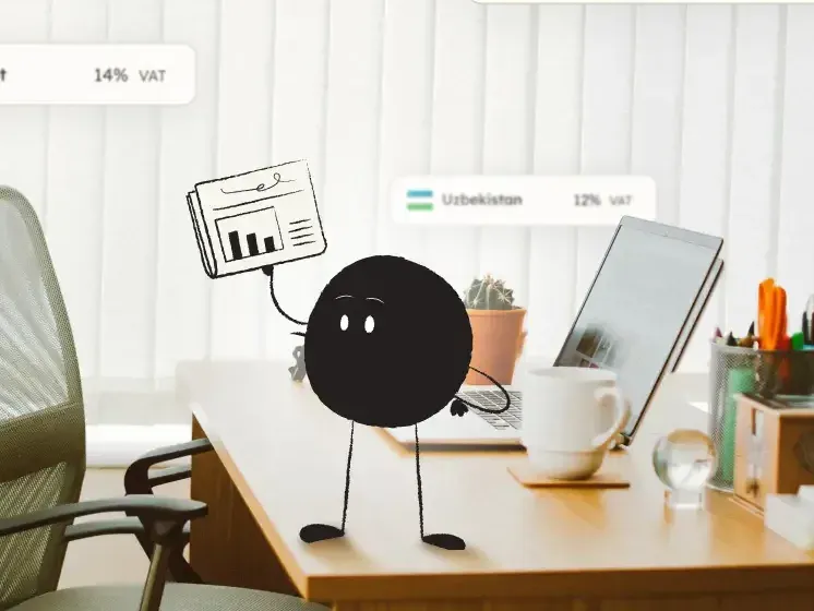Qoodle on a desk with VAT rates for the UK, Luxembourg, and Egypt floating around